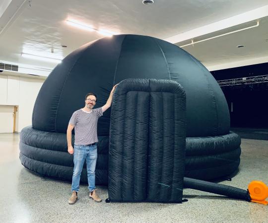 Trevor standing beside inflatable planetarium dome